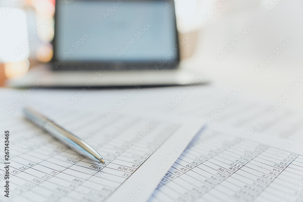Taxes and accounting. Summary table. Pen and notebook on papers with calculations. Taxes and accounting. Summary table. Pen and notebook on papers with calculations.