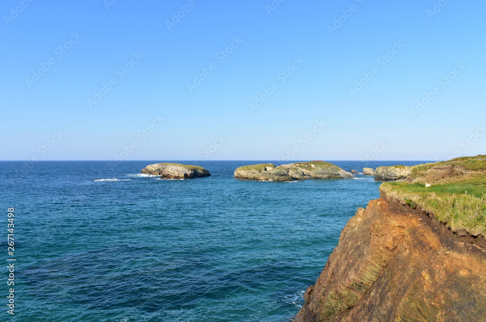 Cliff with grass and islands, blue sea and sunny day. Galicia, Spain. Cliff with grass and islands, blue sea and sunny day. Galicia, Spain.