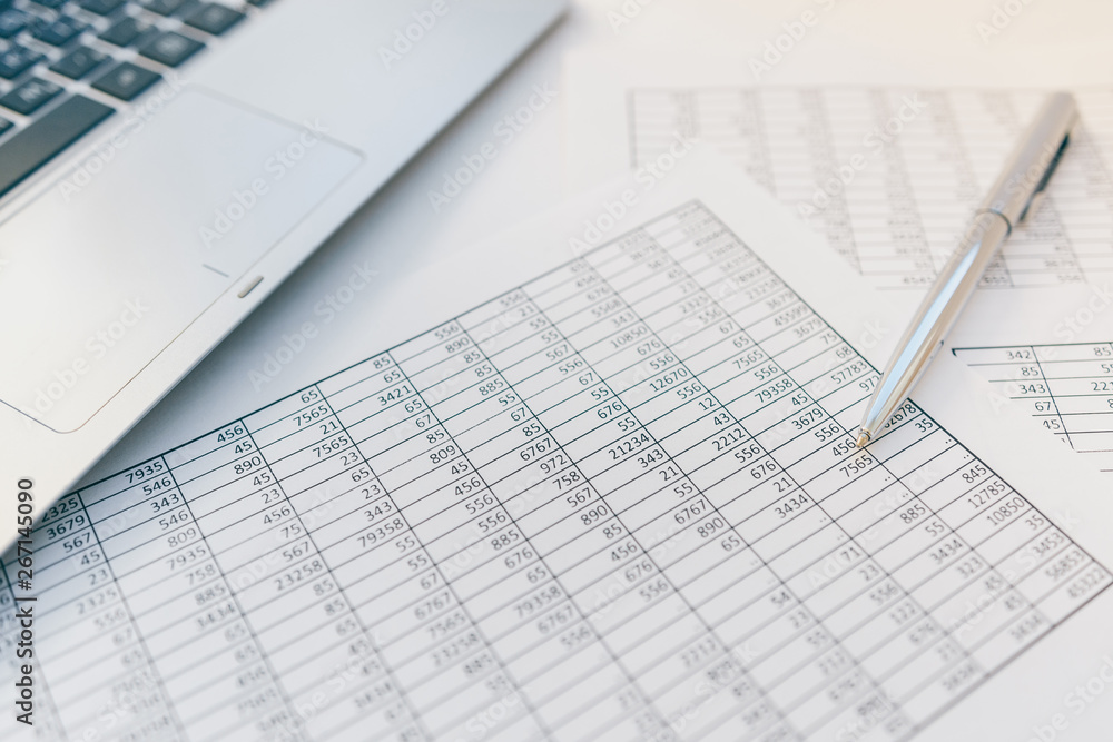 Taxes and accounting. Summary table. Pen and notebook on papers with calculations. Taxes and accounting. Summary table. Pen and notebook on papers with calculations.