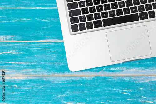 Top view of silver laptop / notebook on wooden table with copy space