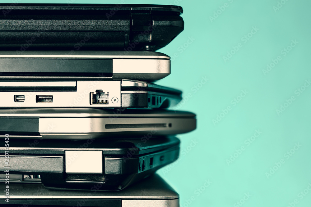 Stack of laptops / notebooks on turquoise background with copy space Stack of laptops / notebooks on turquoise background with copy space