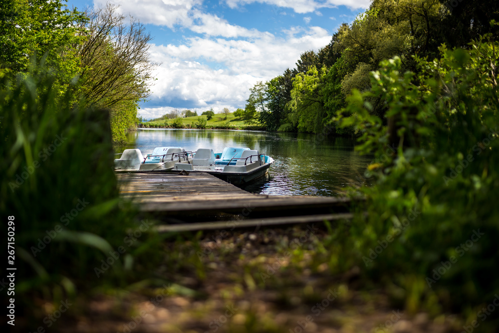 Fototapeta premium zwei Tretzwei Tretboote an einem See mit Stegboote an einem See mit Steg