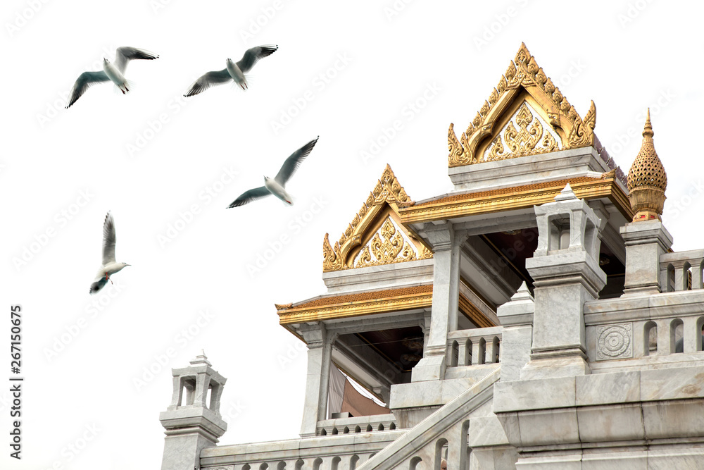 Architectural detail from exterior view of the Buddhist temple, Wat Traimit over clear sky with flying seagulls in Bangkok, Thailand Architectural detail from exterior view of the Buddhist temple, Wat Traimit over clear sky with flying seagulls in Bangkok, Thailand