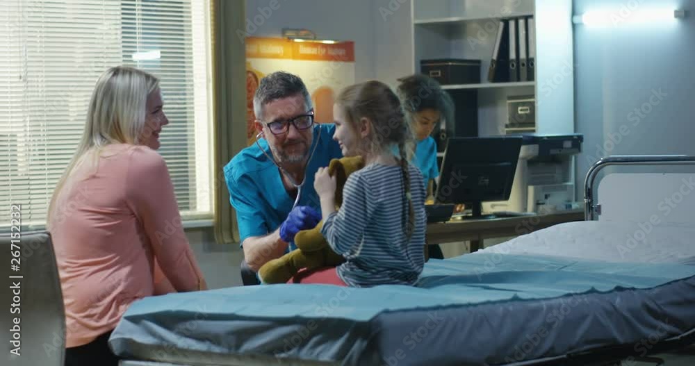 Friendly doctor examining teddy bear with stethoscope Friendly doctor examining teddy bear with stethoscope