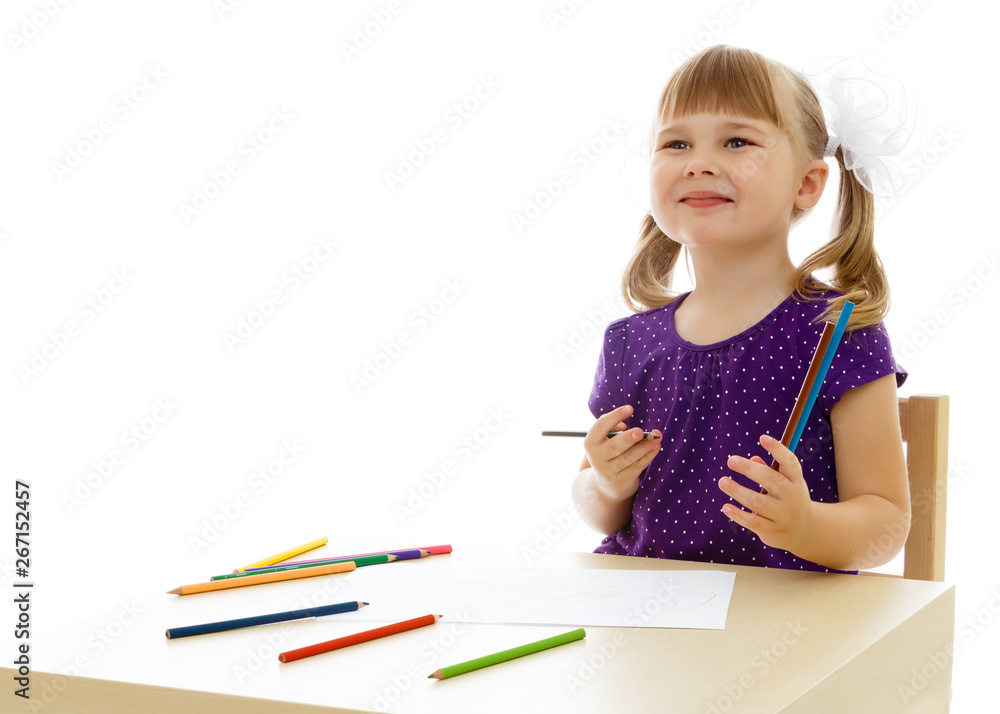 A little girl is drawing at the table. A little girl is drawing at the table.