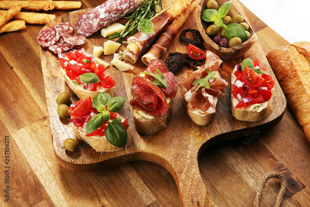 antipasto various appetizer. Cutting board with prosciutto, salami, cheese, bread and olives on dark wooden background antipasto various appetizer. Cutting board with prosciutto, salami, cheese, bread and olives on dark wooden background