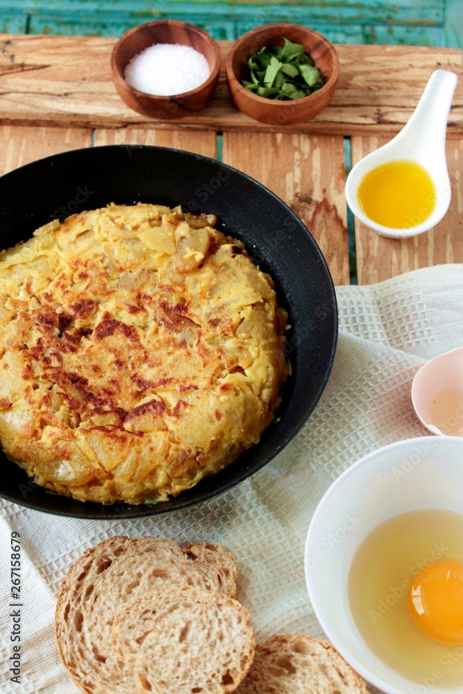 Tortilla de patatas y cebolla en la sartén sobre fondo de madera Tortilla de patatas y cebolla en la sartén sobre fondo de madera