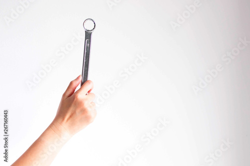 hand holding a ring spanner on white background