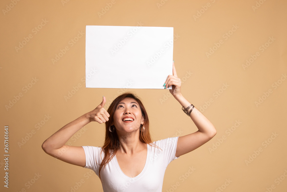 Young Asian woman show thumbs up with white blank sign. Young Asian woman show thumbs up with white blank sign.