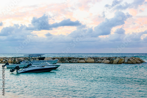 Speedboats/ Motorboats docked on the beach at sunset on tropical Caribbean island. Holiday luxury resort setting. Vacation boat rentals.