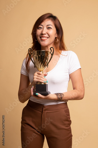 Successful young asian woman holding a trophy. photo