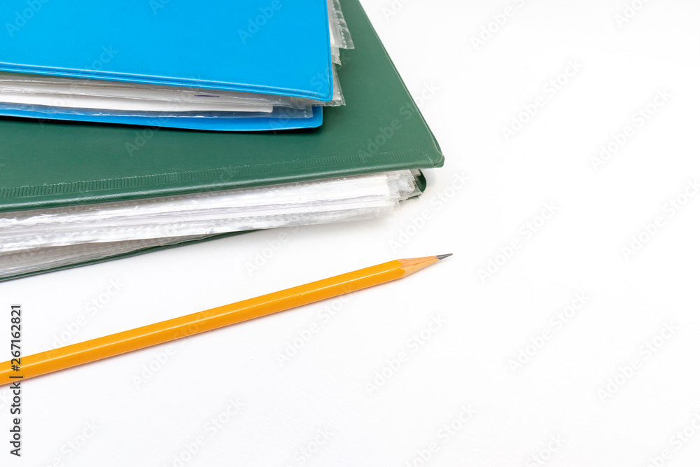 Cropped colorful folders with documents and bills and a yellow pencil on white table with copy space Cropped colorful folders with documents and bills and a yellow pencil on white table with copy space