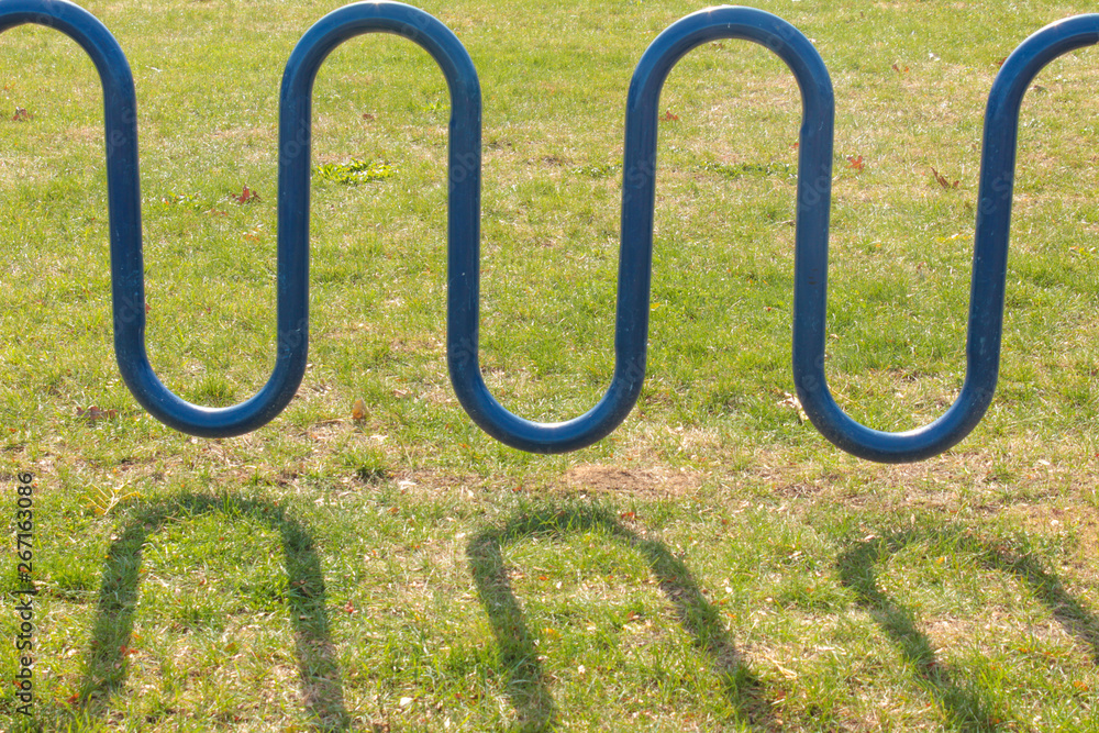 blue curvy bike rack in grass