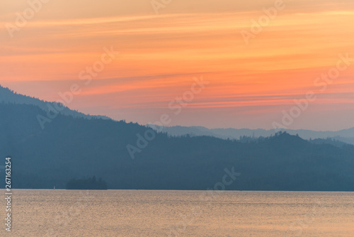 Hazy mountains behind a lake at sunset photo