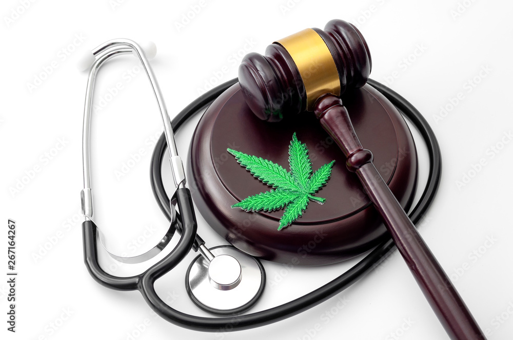 Legal medicinal marijuana, weed dispensary and therapeutic use of cannabis concept theme with a hemp leaf, medical stethoscope and a wood gavel isolated on white background