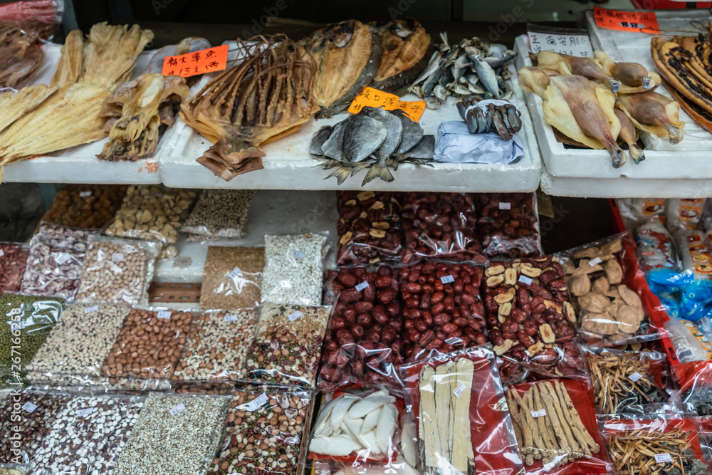 Hong Kong, China - March 8, 2019: Tai Po Market in New Territory. Closeup of Selection of dried seeds, nuts and fish on display in open window. Variey of colors. Hong Kong, China - March 8, 2019: Tai Po Market in New Territory. Closeup of Selection of dried seeds, nuts and fish on display in open window. Variey of colors.