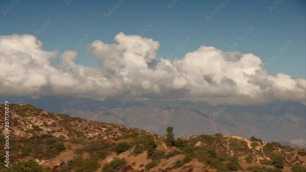 Time lapse clouds roil over a mountain range. Time lapse clouds roil over a mountain range.
