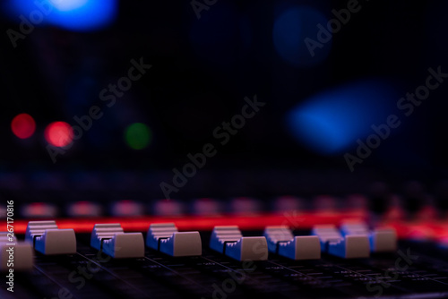 Close up of faders on an audio mixing console in a concert venue