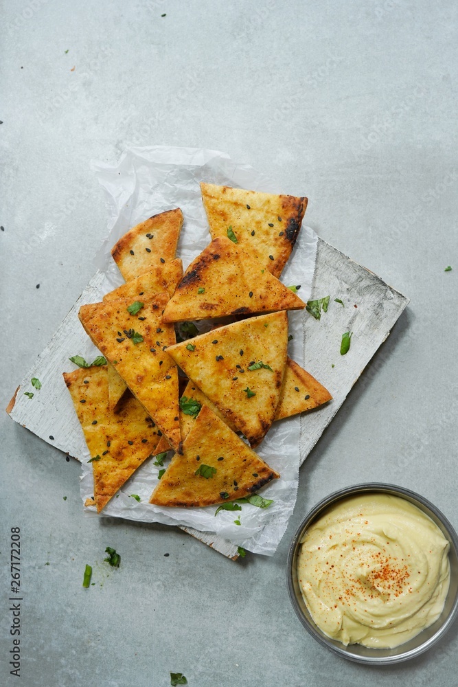 Homemade Lavash Pita Chips served with Hummus, selective focus Homemade Lavash Pita Chips served with Hummus, selective focus