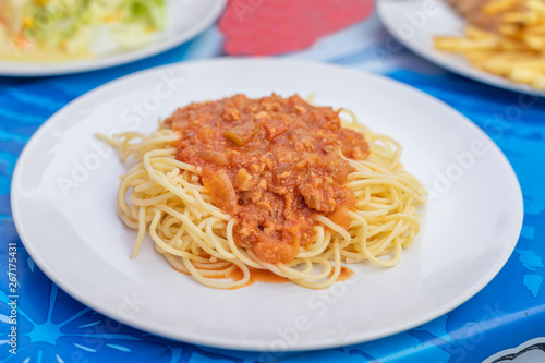 Spaghetti with tomato sauce in dish white.