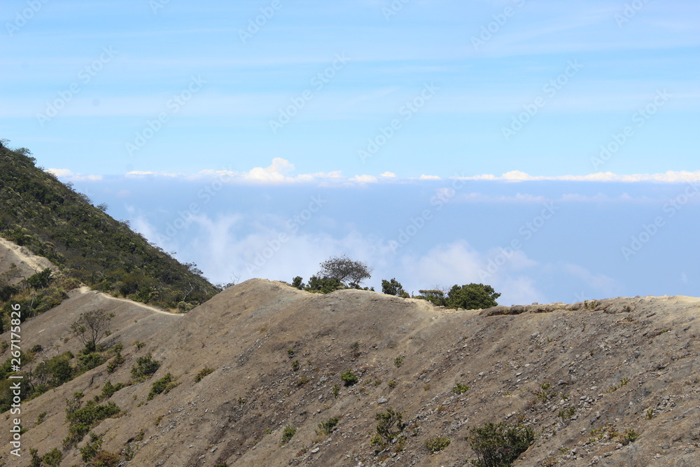  the clear sky above the volcanic crater that surrounds the clouds