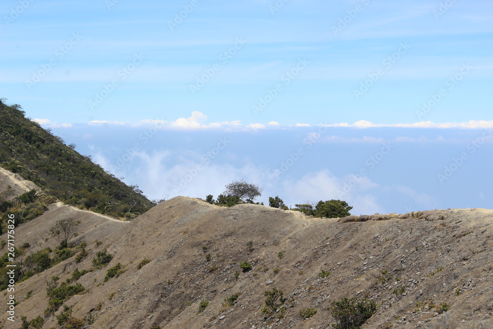 the clear sky above the volcanic crater that surrounds the clouds the clear sky above the volcanic crater that surrounds the clouds
