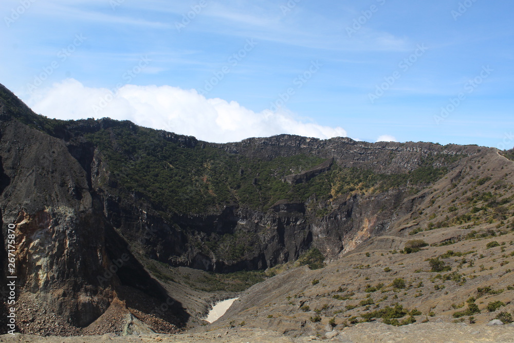  the clear sky above the volcanic crater that surrounds the clouds