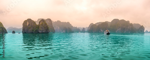 Tableau sur toile Beautiful Tourist cruise ship floating among limestone rocks at Ha Long Bay