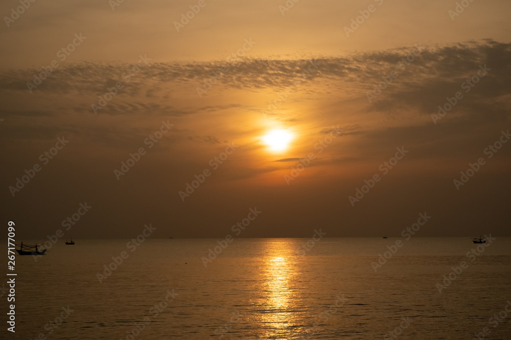 view of sunrise over the sea with fisheries boats
