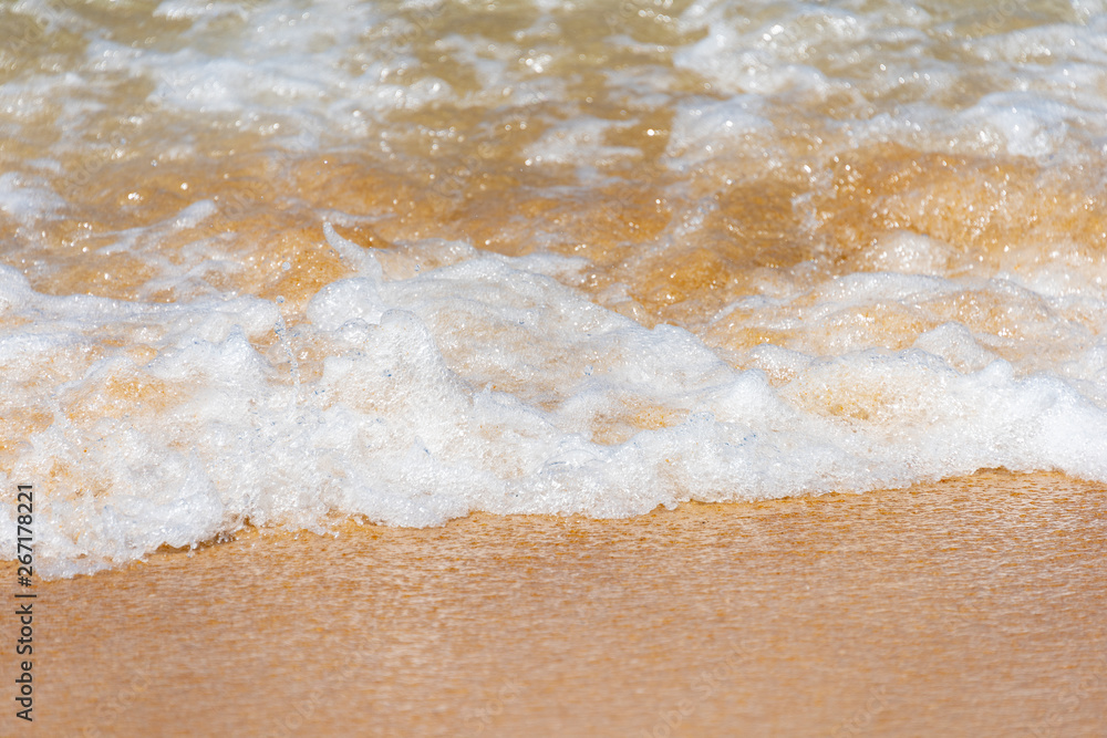 White Splash Wave on the Surface of the Green Sea on the Golden Sand Beach and Blue Sky White Splash Wave on the Surface of the Green Sea on the Golden Sand Beach and Blue Sky