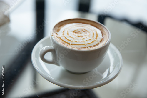 hot coffee in white cup , hot latte art on the black background 