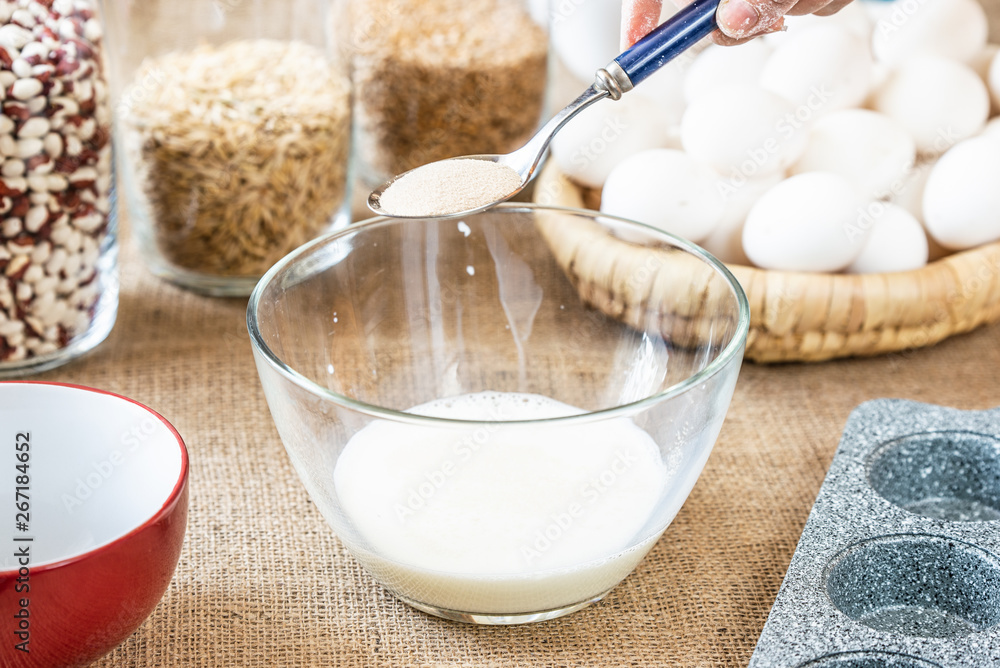 A glass plate with milk and a spoon of yeast A glass plate with milk and a spoon of yeast