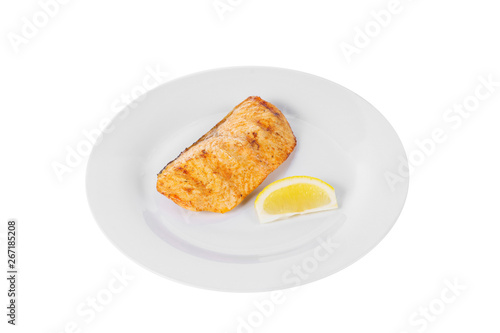 Fish, trout, keta, pink salmon, a piece, baked, fried over an open fire with a slice of lemon. Appetizing on white isolated background side view