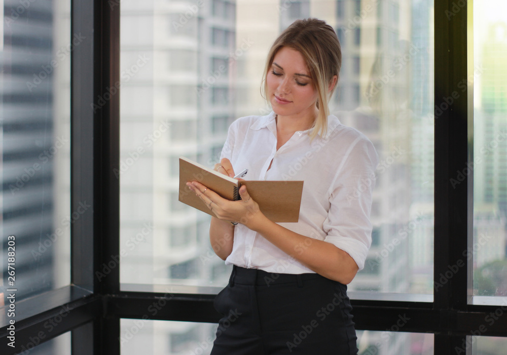 Portrait of a businesswoman holding notebook in modern office Portrait of a businesswoman holding notebook in modern office