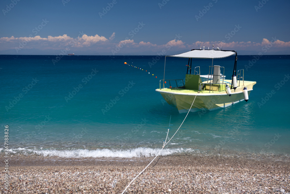 Boat in the bright beautiful transparent sea. Summer, sun, blue turquoise sea
