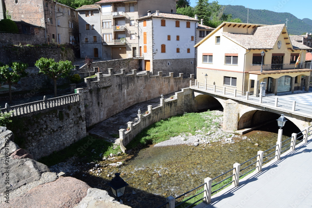 An ancient bridge over a small river in a Spanish town.
