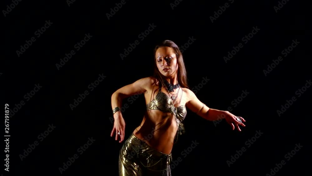 Slender European girl in a national Oriental costume dancing on a black background belly dance. Smooth sexual movements Slender European girl in a national Oriental costume dancing on a black background belly dance. Smooth sexual movements