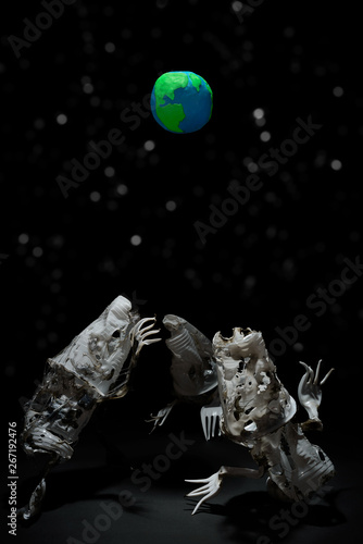 Plasticine Earth planet handmade, above fantasy creatures from plastic on black background with white stars bokeh. Ecology Concept for Earth Hour, Earth Day, Ocean Day and other ECO dates.