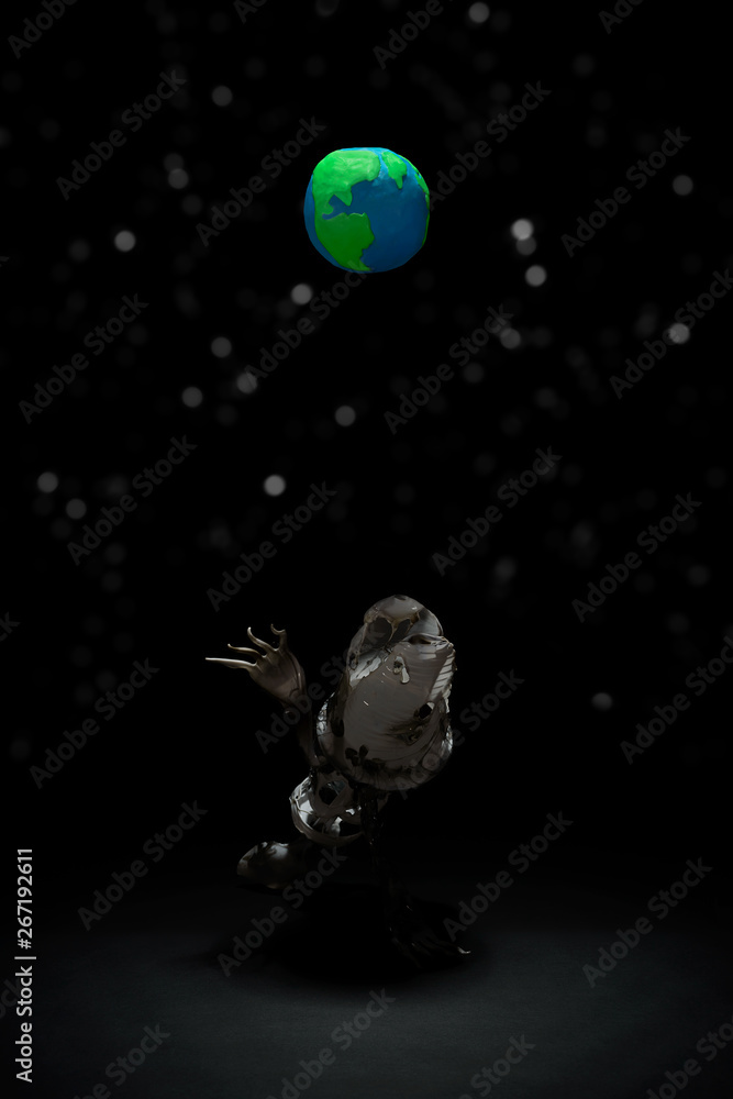 Plasticine Earth planet handmade, above fantasy creatures from plastic on black background with white stars bokeh. Ecology Concept for Earth Hour, Earth Day, Ocean Day and other ECO dates.