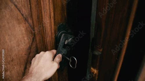 Medieval door with hand opening to dark inside