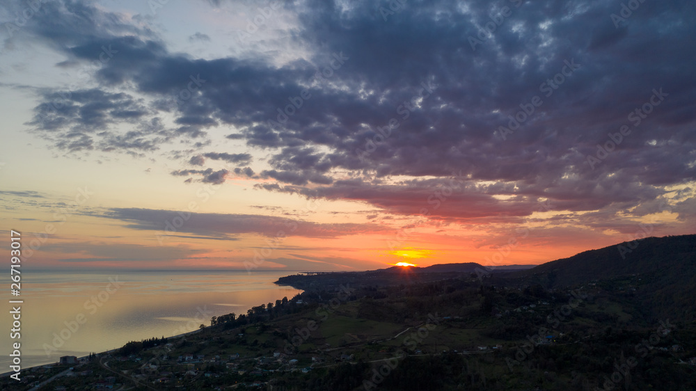 Aerial photography. Evening view of the sea and shore. Sunset over the water. Clouds in the sky.