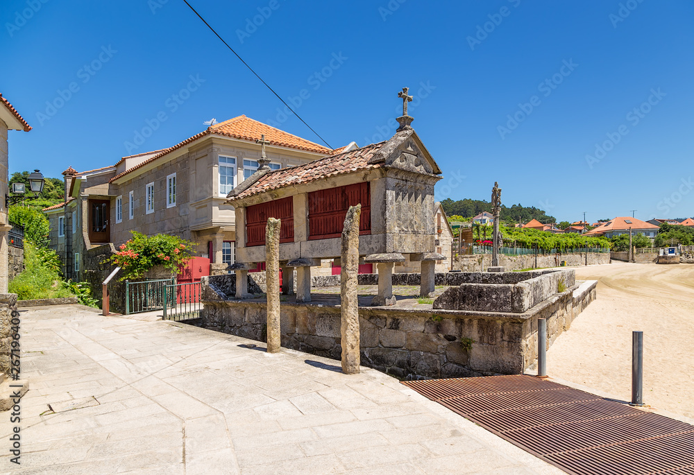 Combarro, Spain. Traditional horreo barn and stone cross in the old town Combarro, Spain. Traditional horreo barn and stone cross in the old town