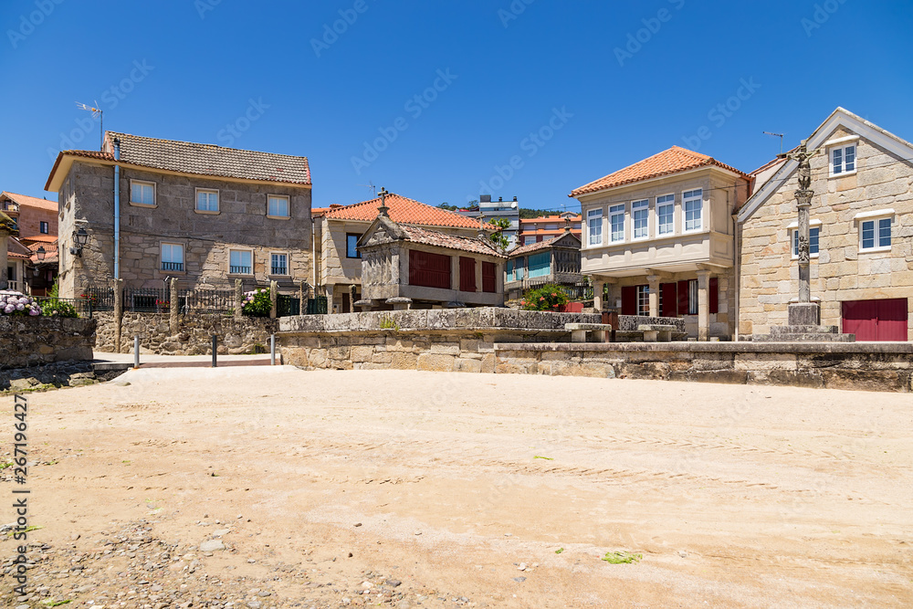 Combarro, Spain. Landscape of the old town with a traditional horreo barn and a stone cross Combarro, Spain. Landscape of the old town with a traditional horreo barn and a stone cross