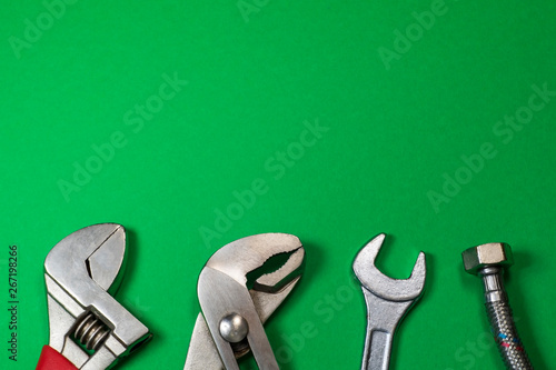 Necessary set of tools for plumbers on a green background. © Виталий Борковский