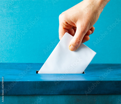 european Union parliament election concept - hand putting ballot in blue election box