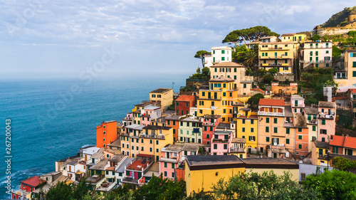 The colorful village of Riomaggiore, Cinque Terre, Italy, on a lovely summer morning. Old traditional Italian terraced houses built at the seaside.