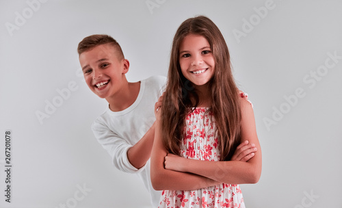 Cute girl and boy on a gray background