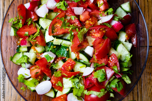 Close-up, delicious fresh vegetable salad cucumber tomatoes radishes cheese greens, vegetarian cuisine, healthy food, diet