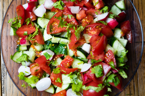 Close-up, delicious fresh vegetable salad cucumber tomatoes radishes cheese greens, vegetarian cuisine, healthy food, diet