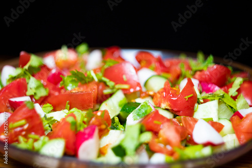 Close-up, delicious fresh vegetable salad cucumber tomatoes radishes cheese greens, vegetarian cuisine, healthy food, diet